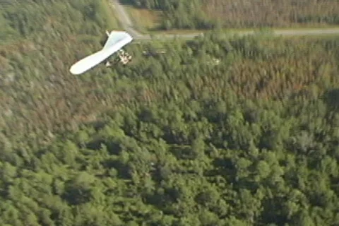 Overhead Hang Glider Swoops Through Frame Aerial Stock Footage