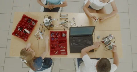 OVERHEAD kids working on a programable robot during robotics class at school Stock Footage 108891826