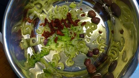 Overhead kitchen shot of sliced celery, sun-dried tomatoes and Kalamata olive Stock Photos