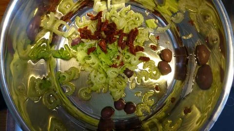 Overhead kitchen shot of sliced celery, sun-dried tomatoes and Kalamata olive Stock Photos
