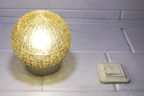 Overhead lamp and an old switch with one push button. Yellow ribbed glass, .. Stock Photos