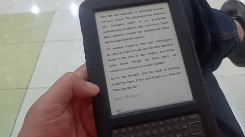 Overhead macro shot of hands operating a third generation Kindle e-reader Stock Footage 344424934