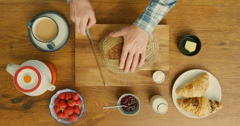 Overhead Of Man Slicing Crusty Bread On Wooden Counter In Kitchen 4K Stock Footage 92181441