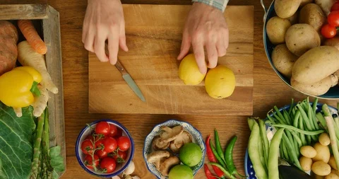 Overhead Of Man's Hand Slicing Lemons On Cutting Board In Kitchen 4K Stock Footage 92478864
