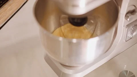 Overhead mixer blending pumpkin pie batter in metal bowl, cinnamon dusting in Stock Footage 346394288