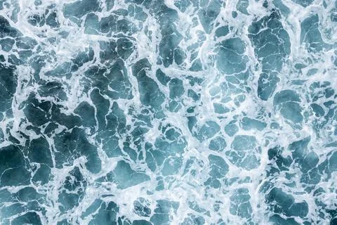 Overhead ocean surface forms foamy turquoise pattern, dynamic sea texture for Stock Photos