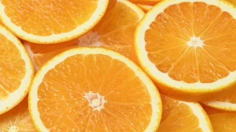 Overhead orange slices rotate in a horizontal frame, showing juicy citrus flesh Stock Footage 346673061