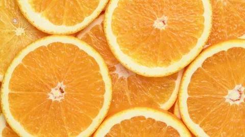 Overhead orange slices rotate in a horizontal frame, forming a juicy citrus Stock Footage 346673167