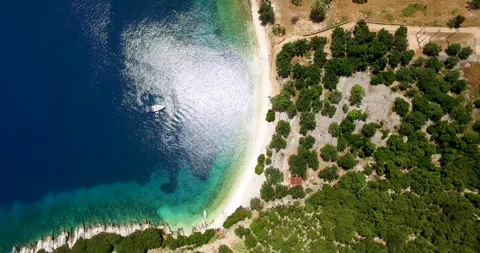 Overhead orbiting drone shot of Foki Beach, a secluded public resort near Stock Footage 269028837