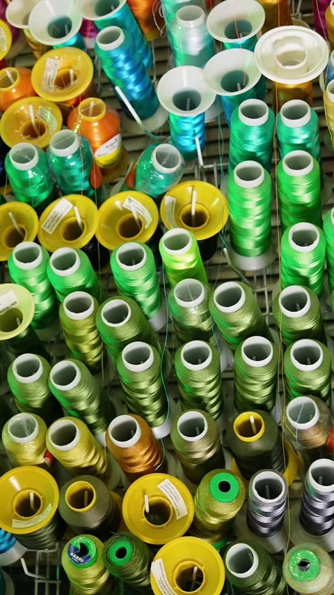 Overhead pan of colorful embroidery thread spools in workshop. Видео 337519550