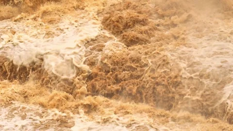 Overhead perspective shows floodwaters surging forcefully over rocks. Stock Footage 310708515