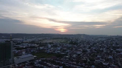 Overhead perspective of a sprawling metropolitan area bathed in the soft sunset Видео 320106534