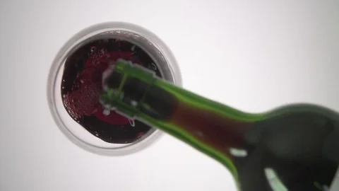 Overhead pouring red wine into wine glass onto white plexi 스톡 동영상 76131218