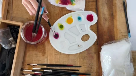 Overhead pull out of hands mixing colors on the palette Stock Footage 330611760