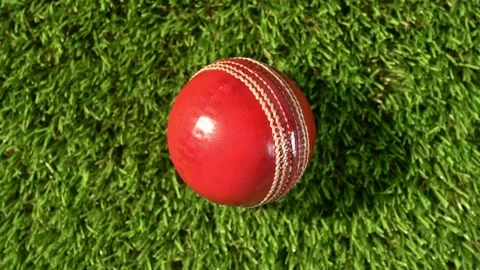 An overhead of a red and white cricket ball from a rotating camera Stock Footage 237458850