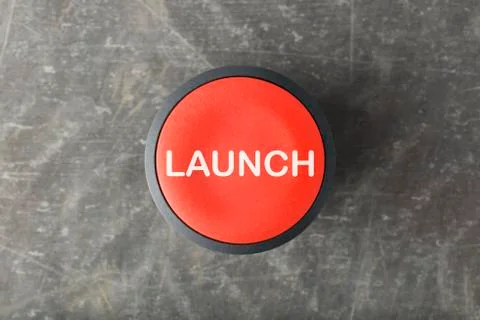 Overhead of Red 'Launch' Push Button on Concrete Background Stock Photos