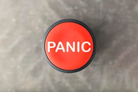 Overhead of Red Panic Button Over Blurred Gray Background Foto stock