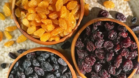 Overhead rotating display of three raisin varieties in wooden bowls showing.. Stock Footage 339462703