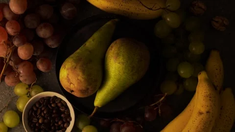 Overhead rotating pears with grapes bananas coffee beans and walnuts Stock Footage 320566802