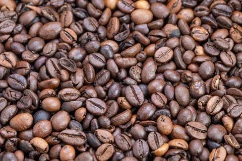 Overhead scattered coffee beans creating repeating pattern and textured surfa Stock Photos