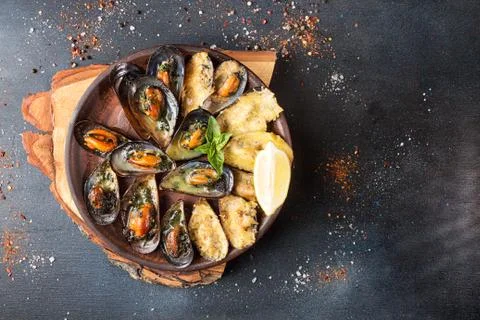 Overhead of seafood dinner table. Grilled baked mussels with butter, parsley  Foto stock