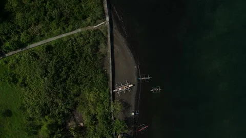 Overhead shot of a black sand beach lined with boats. Vídeos de archivo 335588215