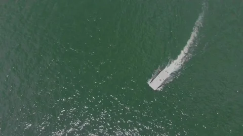 Overhead shot of boat cutting through green lake Stock Footage 135691610