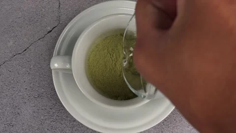 Overhead shot of brewing matcha or green tea with glass cup Stock Footage 278031348