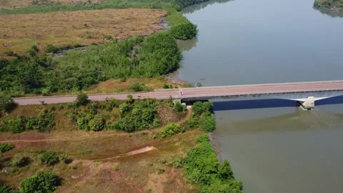 Overhead shot of a bridge spanning a river, revealing the natural beauty of the Stock Footage 317449031