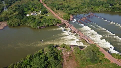 Overhead shot of a bridge spanning a river with a waterfall in guinea Stock Footage 318495145