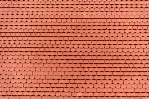 Overhead shot captures the repeating pattern of red clay tiles covering roof Stock Photos
