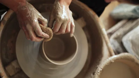 Overhead shot capturing a potter's hands gently smoothing the surface of a .. Stock Footage 272839689
