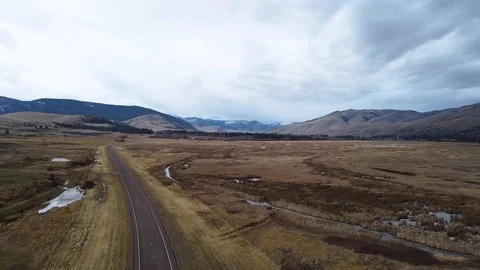 Overhead shot of car cruising down empty highway in Montana Stock Footage 125049996