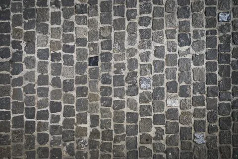 Overhead shot of a cobblestone structure on the ground of an urban street. Stock Photos