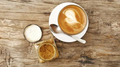 Overhead shot of coffee cup with art latte depicting a heart. Stock Footage 334648919