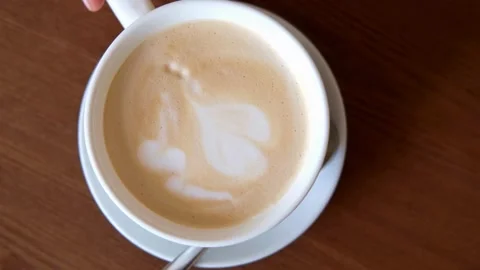 Overhead shot of coffee cup with art latte depicting a heart. Stock Footage 334648930