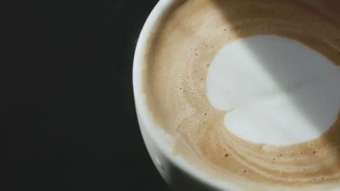 Overhead shot of coffee cup with art latte depicting a heart. Stock Footage 334649067