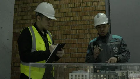 Overhead shot of construction professionals discussing project plans outdoors Stock Footage 323169099