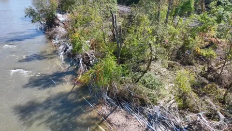 Overhead shot of damaged plastic pipe along the French Broad river.  Video stock 292424177