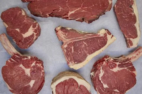 Overhead Shot Of Different Cuts Of Beef Steak On Background In Butcher's Sh.. Stock Photos