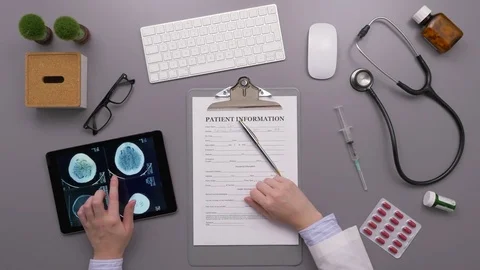 Overhead Shot Of Doctor Using Digital Tablet And Filling Form Stock Footage 79650153