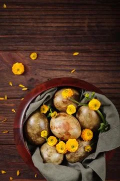 Overhead shot of dyed Easter eggs and yellow flowers in a bowl Foto stock