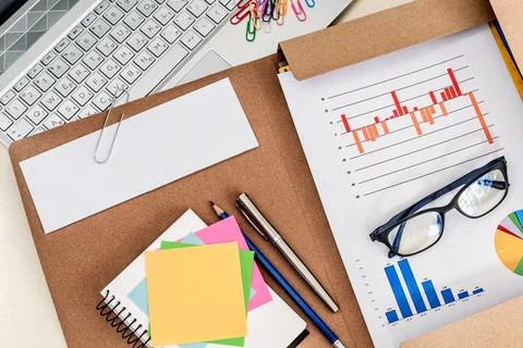 Overhead shot of a financial data chart, laptop and note pads on an office de Stock Photos