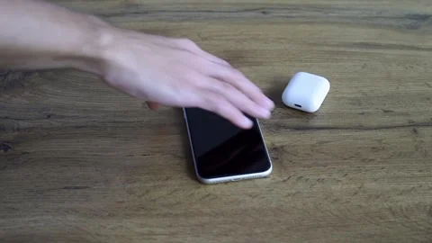 Overhead shot hand takes personal electronic devices from dark wood table Stock Footage 329304088