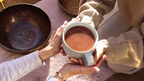 Overhead shot of hands passing a tea cup from one person to another Stockbeeldmateriaal 312074398
