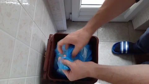 Overhead shot in home kitchen of a full garbage bag removed by a man. Stock Footage 154307183