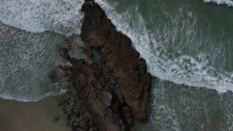 Overhead shot of a large rock with light waves crashing 動画素材 155203279