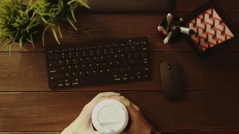 Overhead shot of man with cup of coffee typing on keyboard Stock Footage 81164877