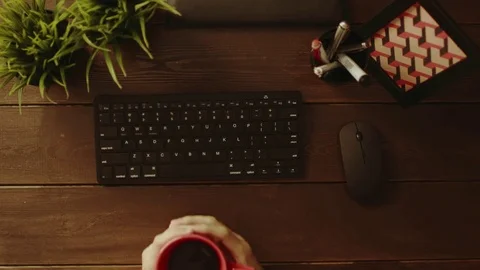 Overhead shot of man drinking coffee while sitting in front of computer Stock Footage 81173257