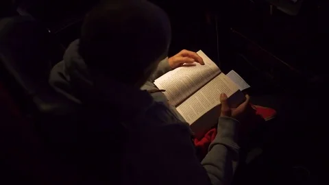 Overhead shot of man reading in the dark Stockbeeldmateriaal 84900724